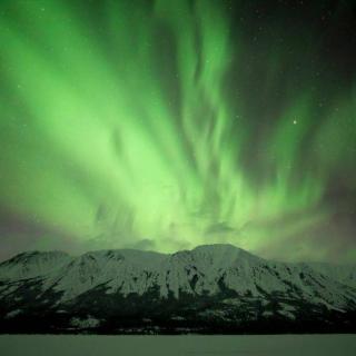 Green aurora over mountain 