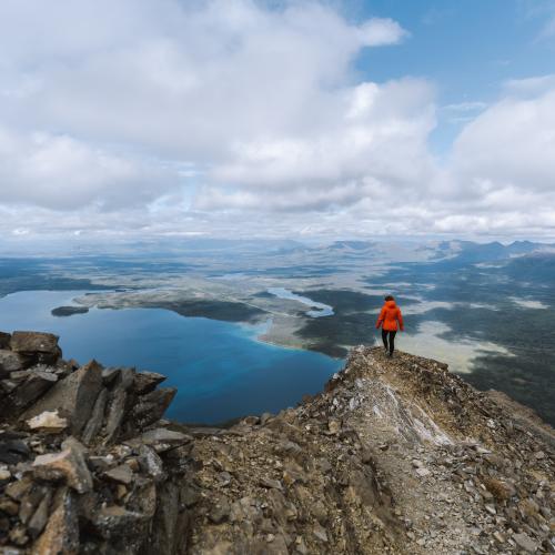 A hiker enjoys the view at the top of King's Throne in Kluane National Park and Reserve